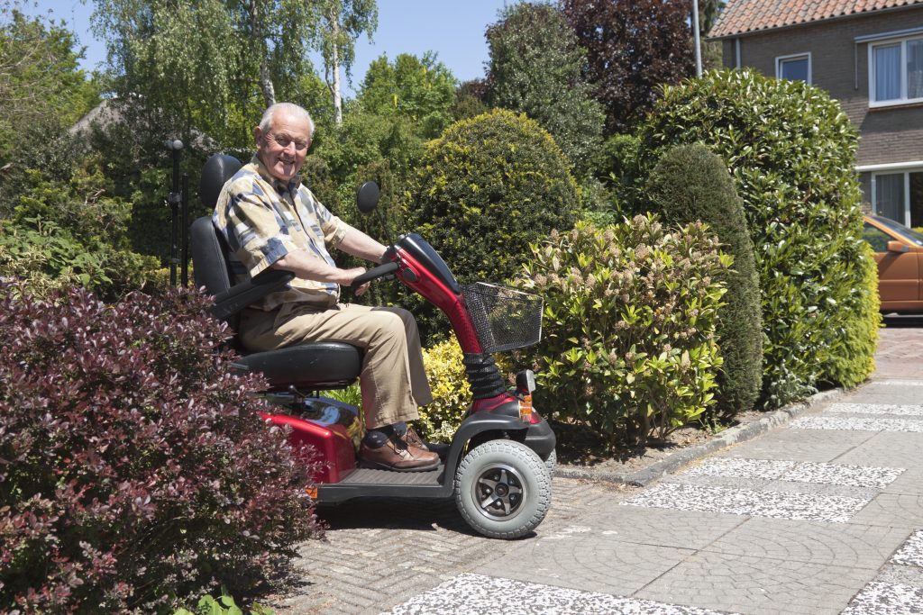 senior man going for a ride on his mobility scooter - for more